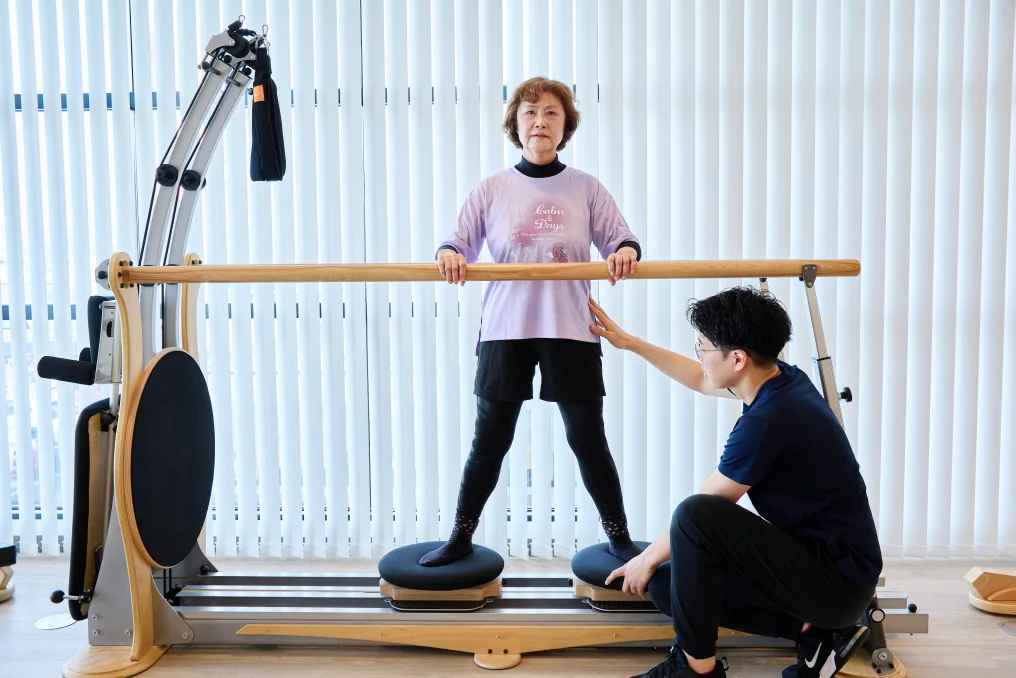 転倒予防トレーニングをする利用者とサポートする理学療法士