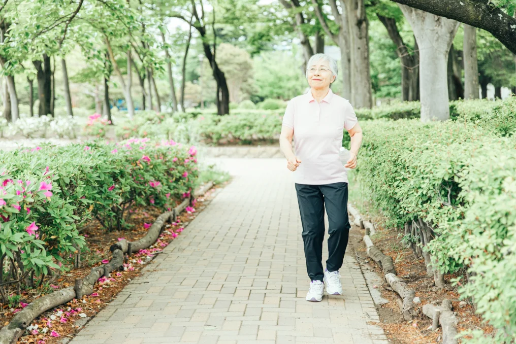 元気に公園を散歩する年配の女性