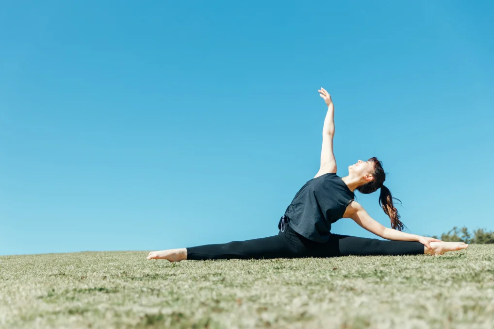 外で元気にバレエの柔軟をする女性