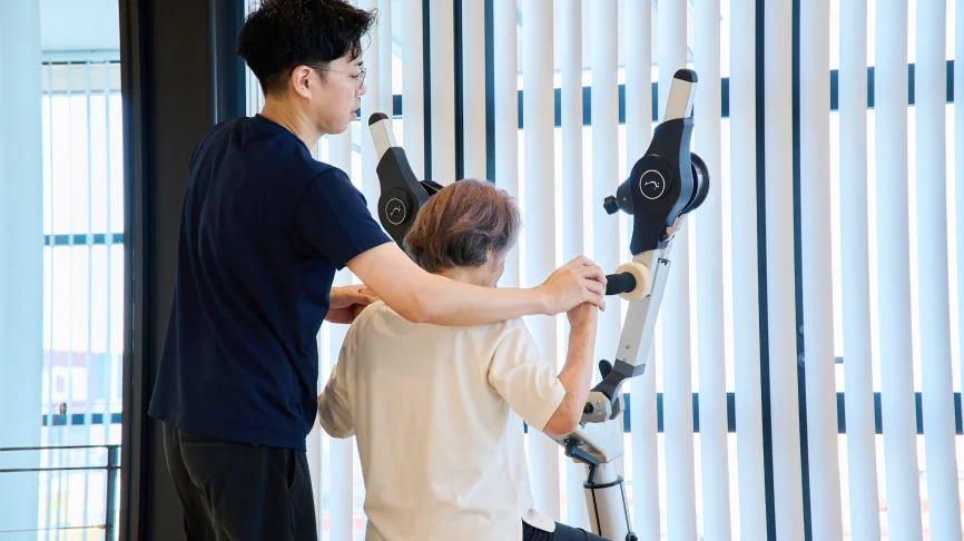 反復運動で神経回路の再構築を促す運動する利用者とサポートする理学療法士