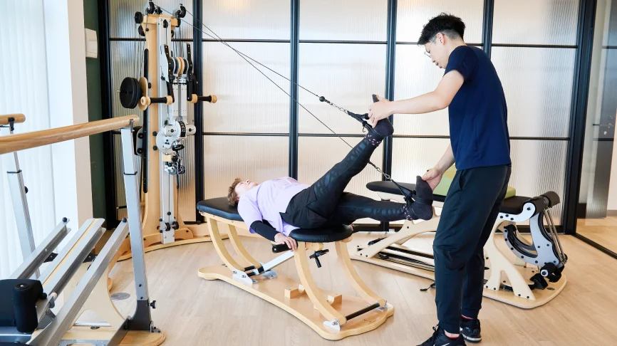 股関節のトレーニングをする女性と指導する理学療法士