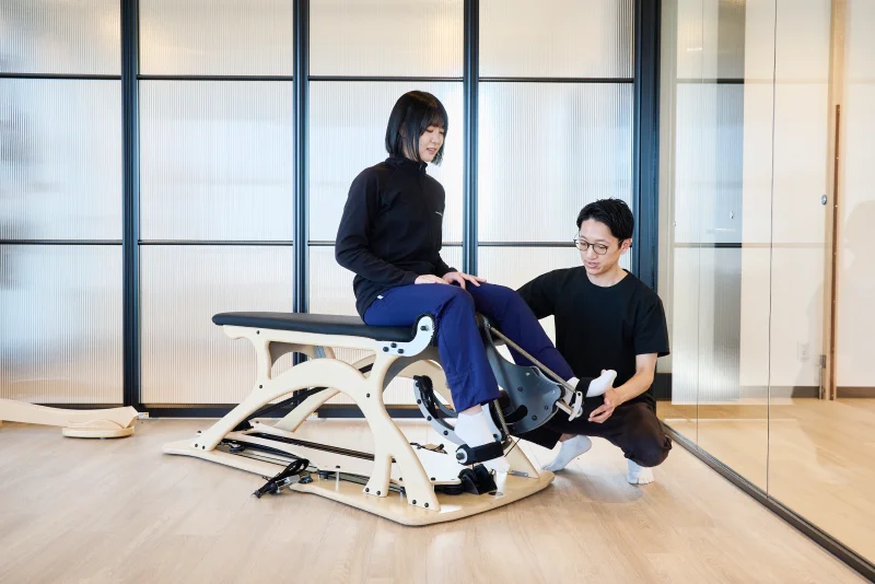 ジャイロトニックのセッションを受ける女性とサポートする理学療法士