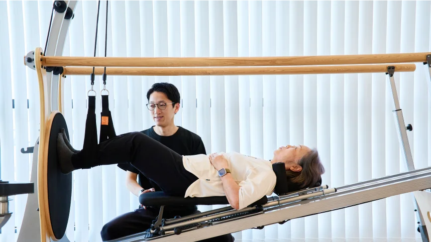 足腰の筋力を効果的に強化トレーニングをする女性とサポートする理学療法士