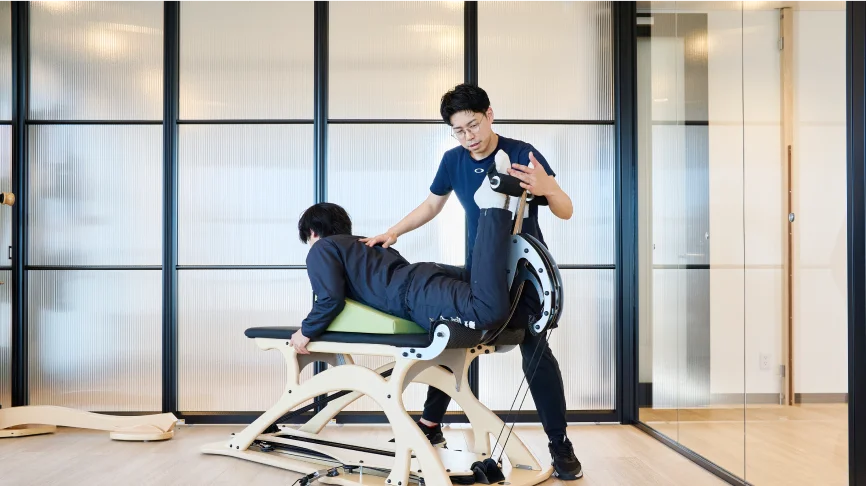 運動する男性と指導する理学療法士